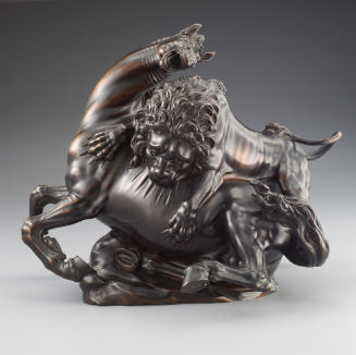 A bronze sculpture of a lion attacking a horse.  The lion is actively clawing and biting into t…