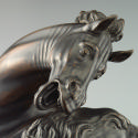 Detail image of a bronze sculpture of a lion attacking a horse.  The lion is actively clawing a…
