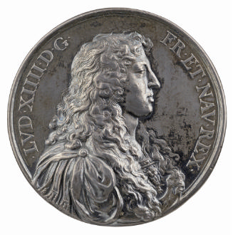 Silver medal of a man in profile to the right with long, curled hair wearing classical arm with…