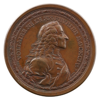 Bronze medal of a man in profile to the right with inscription