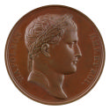 Bronze medal of a man in profile to the right with short hair and a laureate