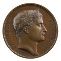 Medal of a man in profile to the right wearing a laurel wreath