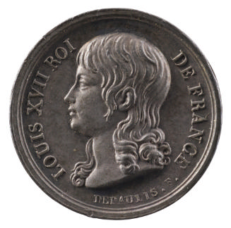 Silver medal of a young boy in profile to the left