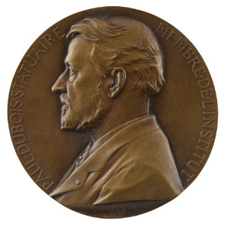 Bronze medal of a man in profile to the left, wearing a cravat and jacket