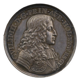 Silver medal of a man in profile to the right wearing a lace cravat and armor