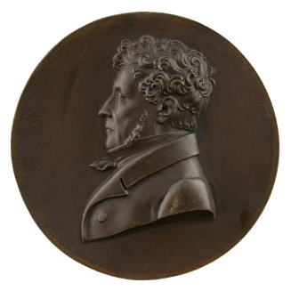 Bronze portrait medal of an unknown man, hair short and curled, with long sideburns, wearing a …