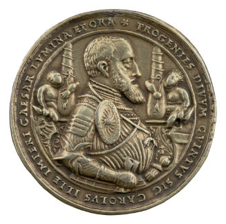 Silver medal of Charles V wearing full armor and holding a scroll in his right hand and a sword…