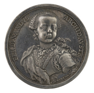 Silver medal of a boy turned three-quarters facing front, wearing a wig and fur mantle