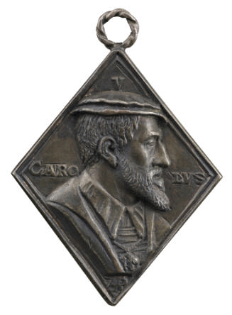 Silver medal of a bearded man wearing a hat, coat, and collar