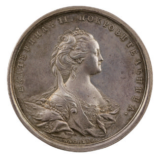 Silver medal of a woman wearing a small crown and a gown