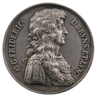 Silver medal of a man wearing a wig in profile to the right