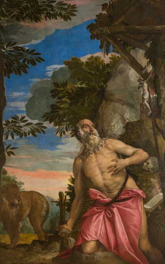 a semi-nude man with a white beard kneels in the wilderness