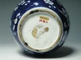 Single blue porcelain covered jar decorated with white floral decorations, bottom of jar.
