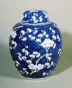 Single blue porcelain covered jar decorated with white floral decorations.