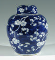 Single blue porcelain covered jar decorated with white floral decorations.