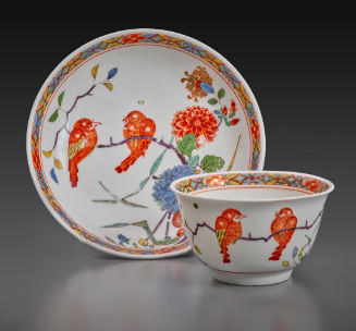 tea bowl and saucer with two orange birds on a branch
