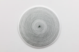 White ceramic disk painted with thin, gray concentric circles and a gray fingerprint at center