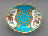 Inside view of basin in blue, white, and gold with images of flowers