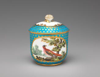Porcelain sugar bowl in blue and gold with an image of a bird in a tree