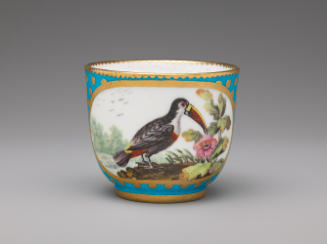 Porcelain cup in blue and gold with image of bird