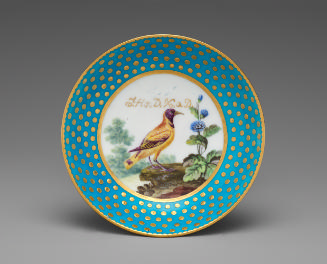 Porcelain saucer in blue and gold with image of bird