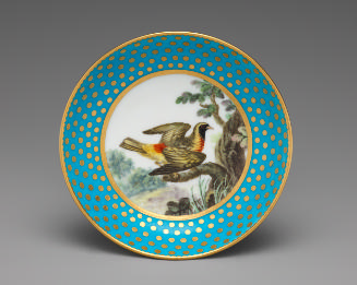 Porcelain saucer in blue and gold with image of bird in tree