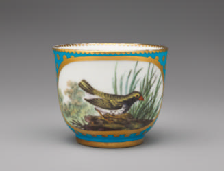 Porcelain cup in blue and gold with image of bird