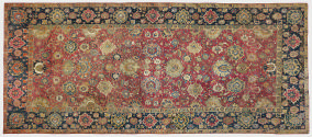 Rectangular red Persian rug with floral design and blue floral border