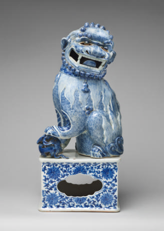 Blue and white porcelain dog sitting on intricately designed base