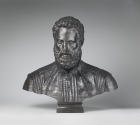 A bronze sculpture of Antonio Galli.  His eyes are facing straight ahead, he has curly hair and…
