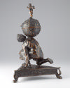 Bronze sculpture of crouching Atlas supporting globe with triangular base; side view