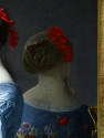 close-up of an oil painting of a woman in a blue dress leaning against a dresser in front of a …
