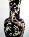 Detail of black ground porcelain vase with branches and white flowers