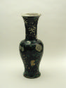 Tall porcelain vase with black ground and floral and vegetal designs