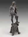 Side view of a bronze sculpture of Hercules.  He is looking straight ahead, with a lion's pelt …