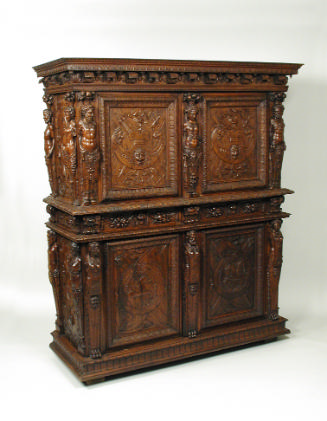 Walnut and pine cabinet with relief carving of trophies, masks, figural decoration, and vegetal…