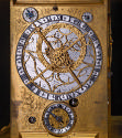 Detail of the main face of the clock with central dial displaying astronomical instruments and …