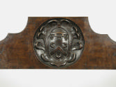 Detail of back of walnut folding armchair, showing crest