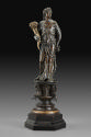 A bronze sculpture of a female figure with a cornucopia.  Her head is turned to her left and sh…