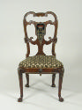 Front view of walnut frame chair with crest and upholstered seat