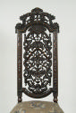 View of walnut chair back with openwork carving