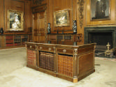 Walnut table with drawers and gilded ornaments, holding books