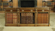 Alternate view of walnut table with drawers and gilded ornaments, holding books