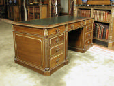 Side view of leather-topped walnut desk with gilded ornaments