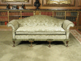 Front view of sofa upholstered in light green silk with a damasque motif