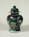 Porcelain covered jar with black ground and animal and vegetal designs