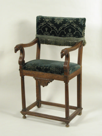Wood chair with patterned upholstery and ram's-head terminals