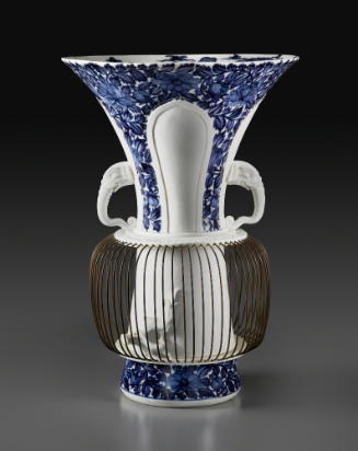 White porcelain vase with blue glaze, a birdcage at the bottom and a handle on each side in the…