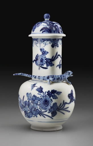 Bulbous white and blue porcelain vase with cover and salamander around the neck, set against a …