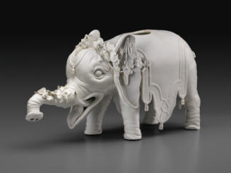 White porcelain wine cooler in the shape of an elephant wearing garlands of grape vines